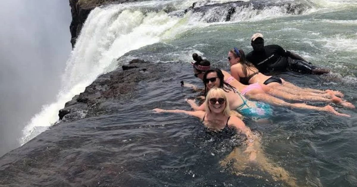 Best Time to Visit Victoria Falls: Month-by-Month Guide 5 People swimming in the Devil's Pool which can be accessed from the Zambian side